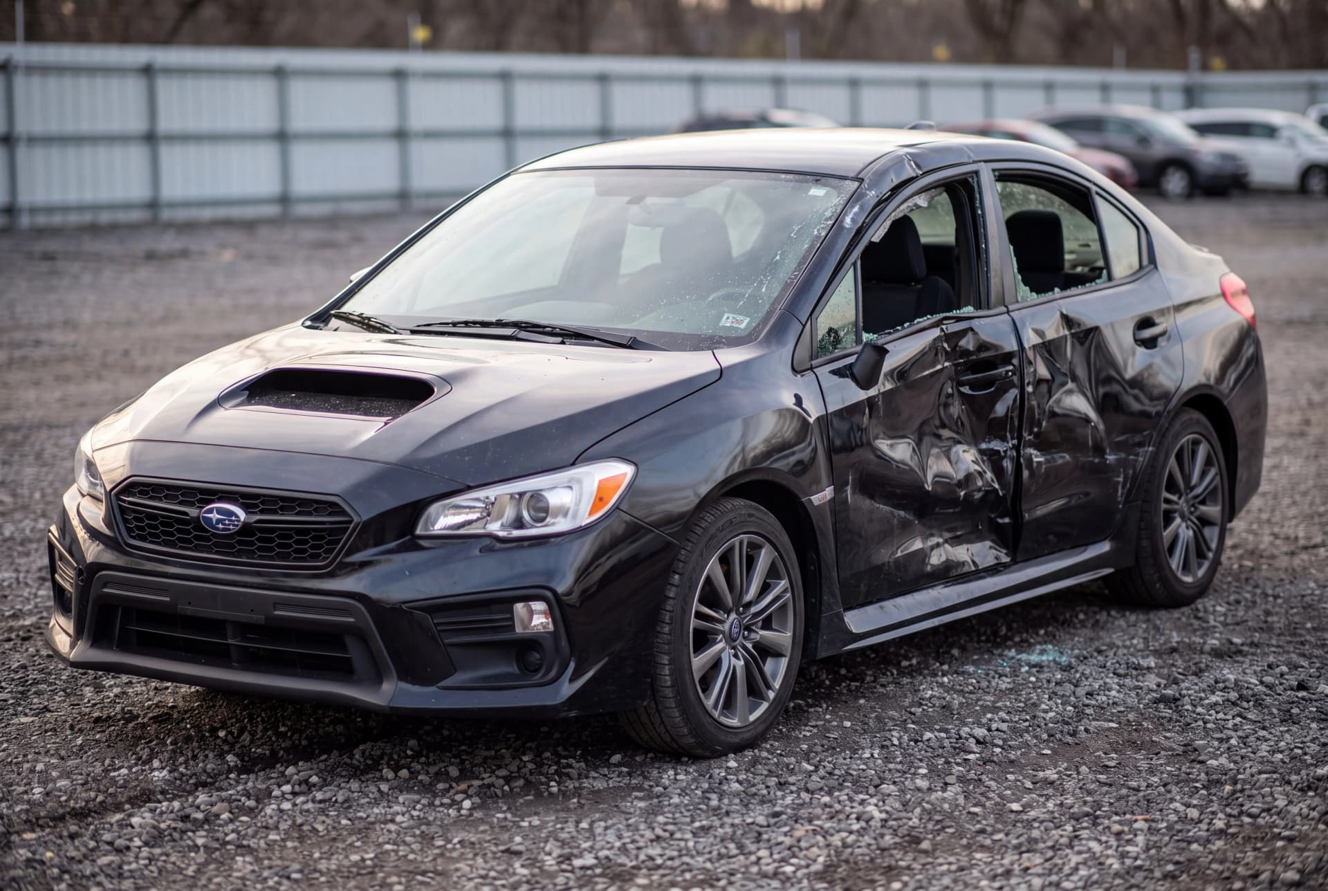A totaled Crystal Black Silica 2021 Subaru WRX CVT Premium after a passenger-side collision
