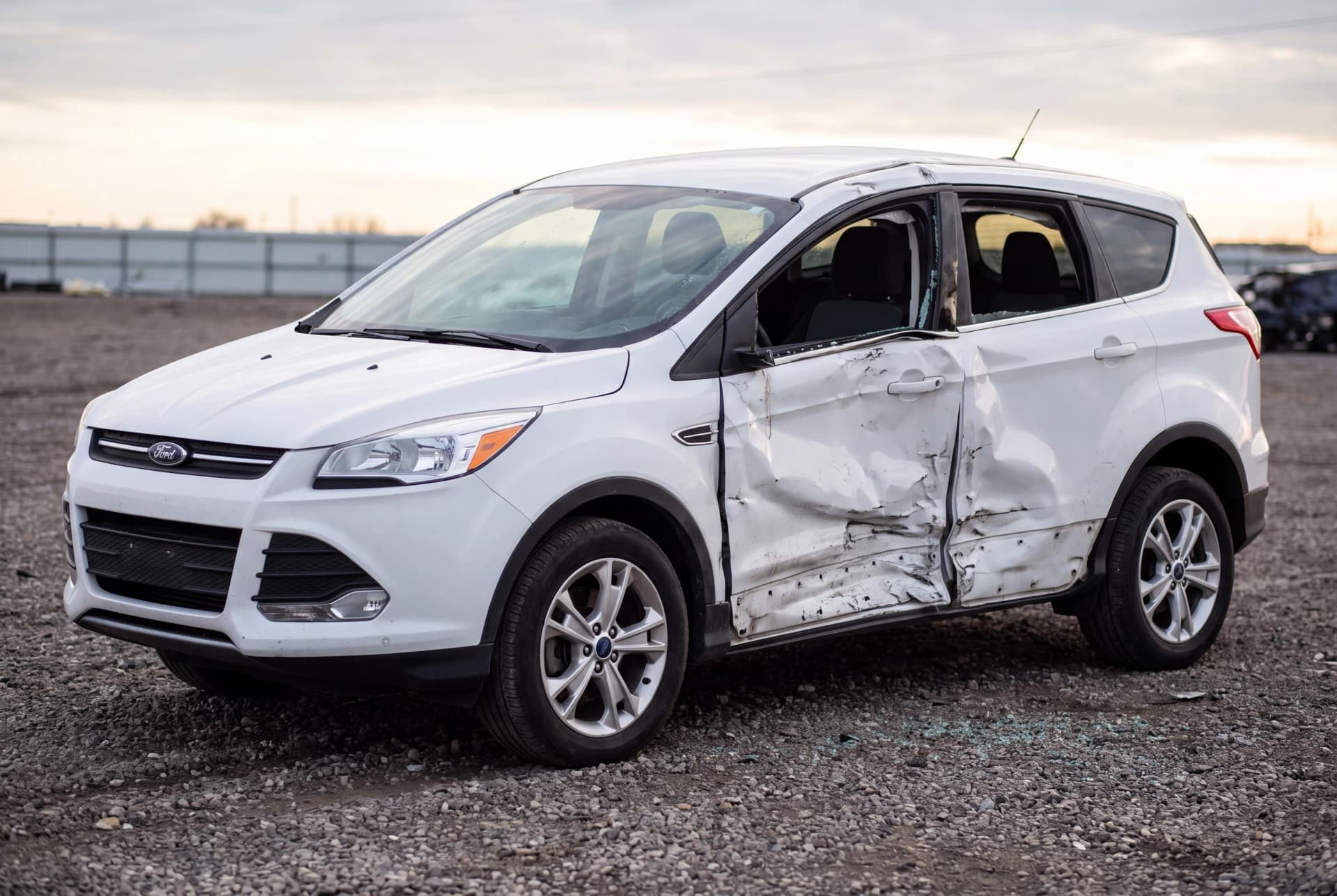 A totaled Oxford White 2016 Ford Escape SE after a passenger-side collision