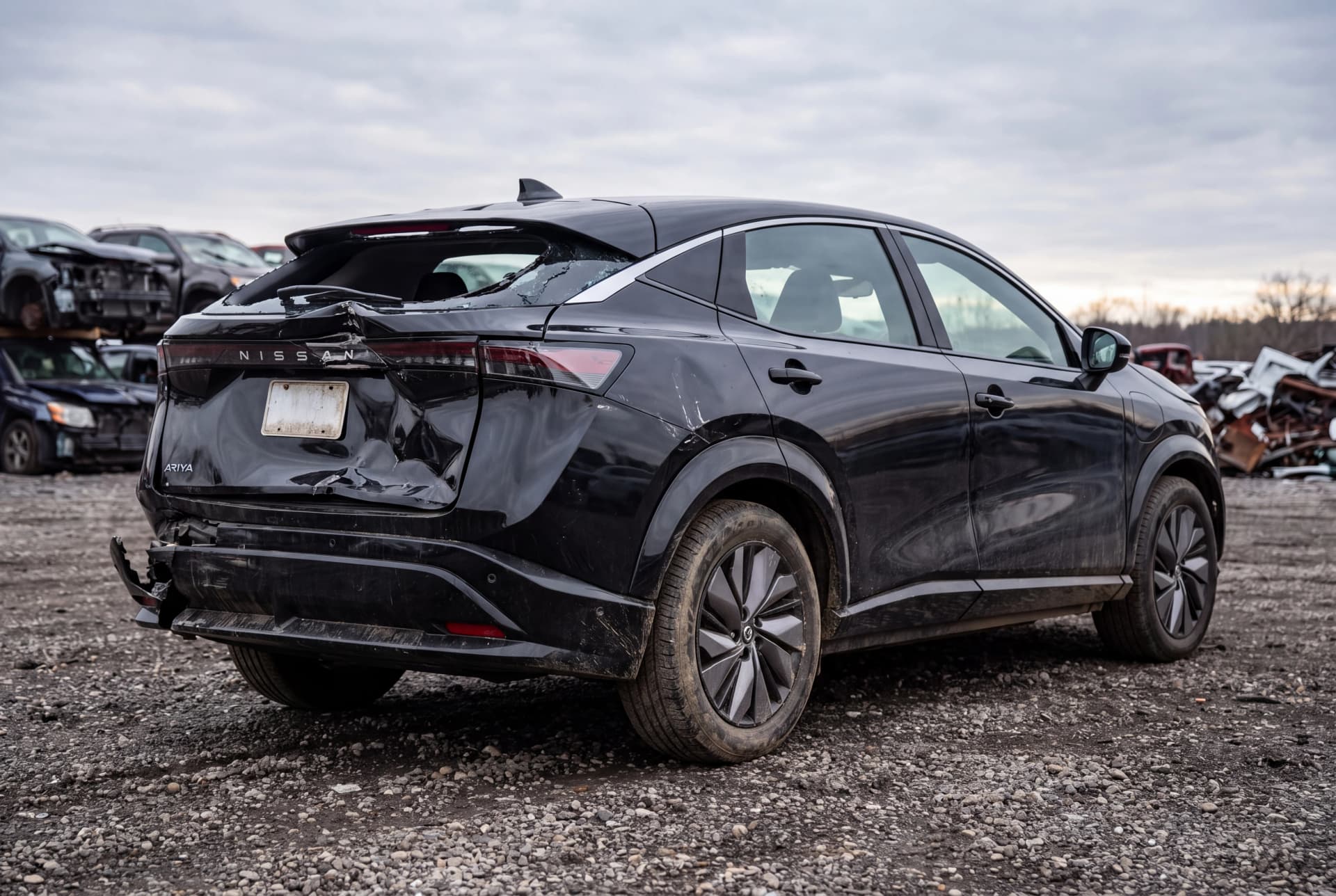 A totaled Black Diamond Pearl 2023 Nissan Ariya Empower+ after a rear-end collision