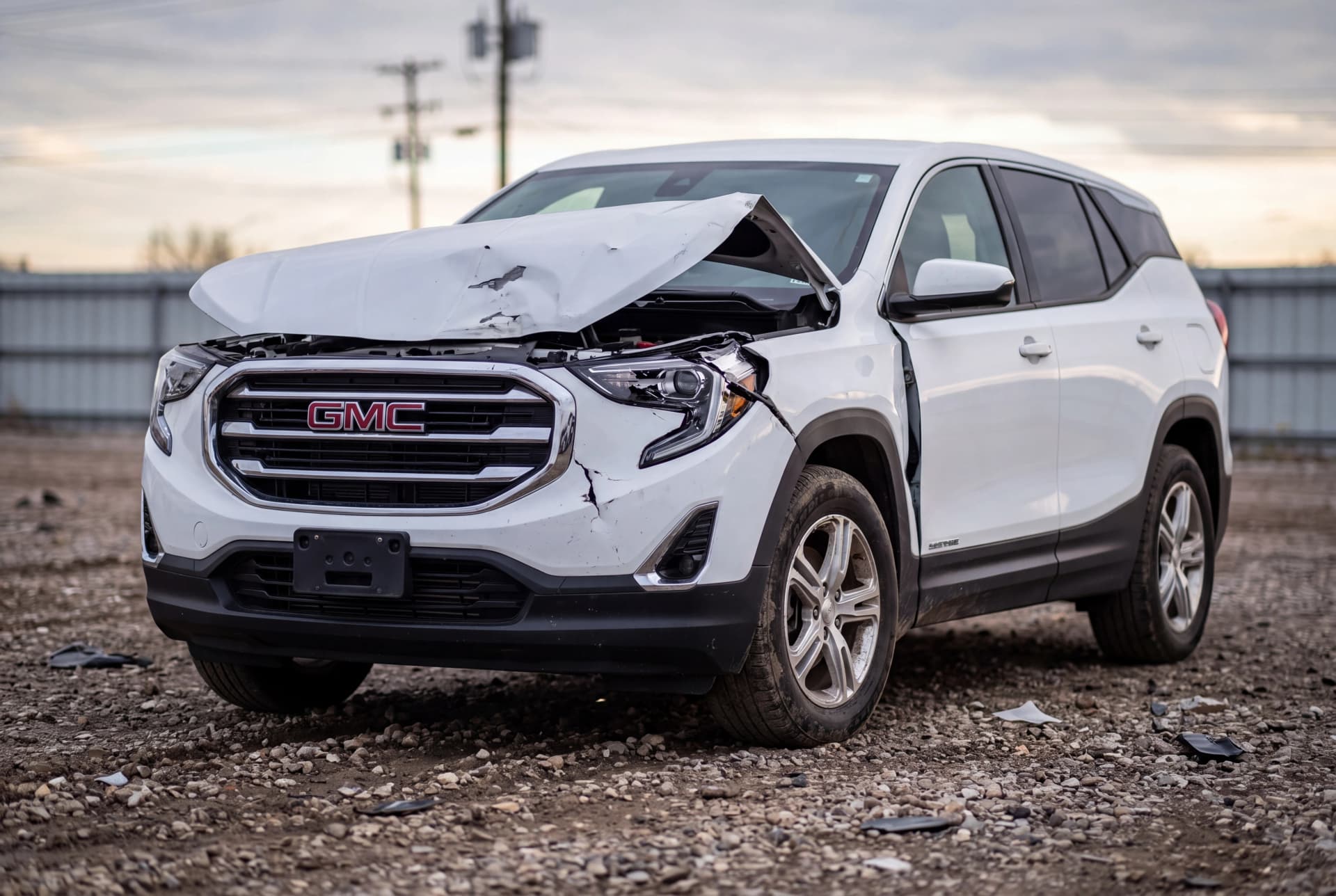 A totaled Summit White 2022 GMC Terrain SLE after a front-end collision