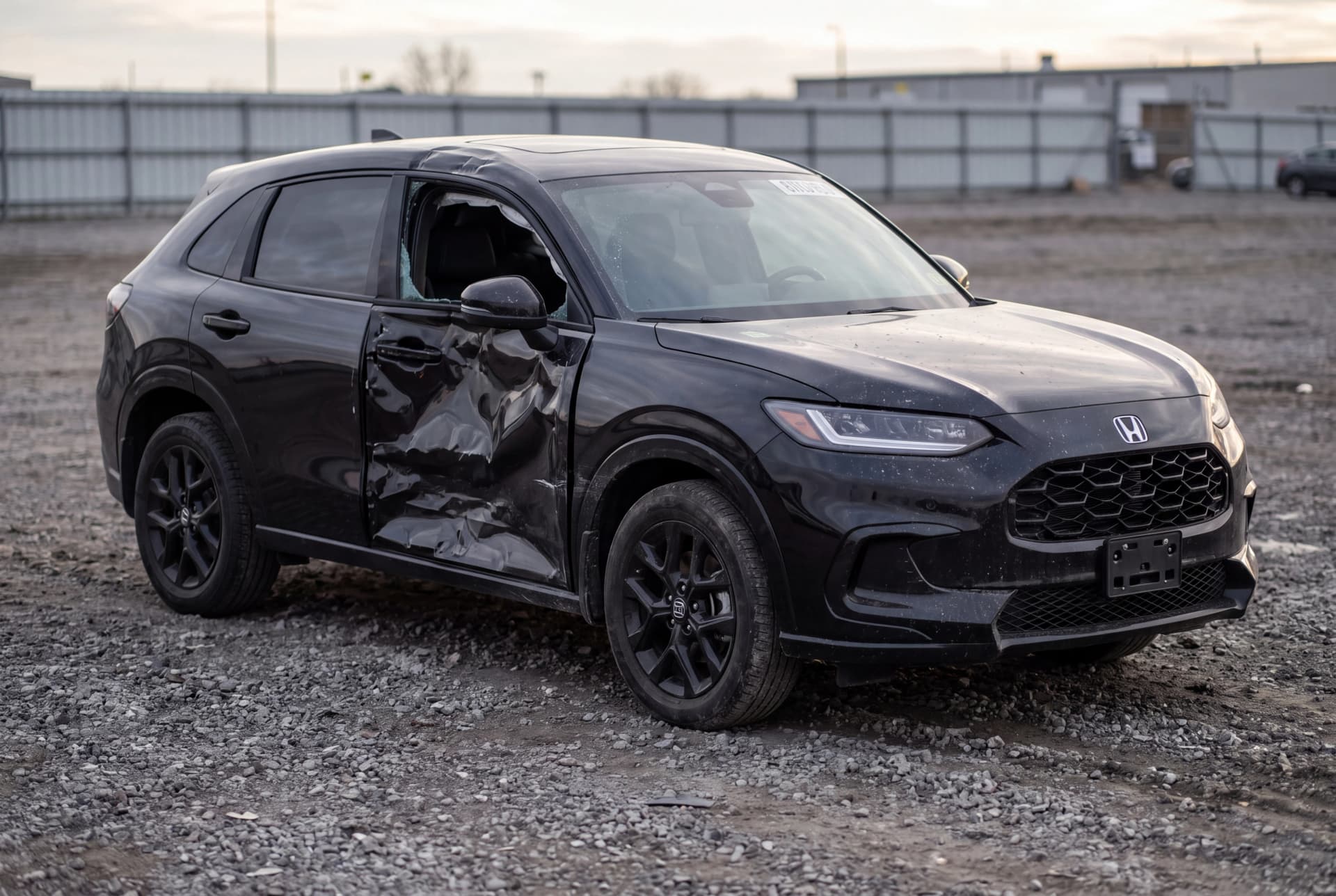A totaled Crystal Black Pearl 2024 Honda HR-V Sport after a driver-side collision