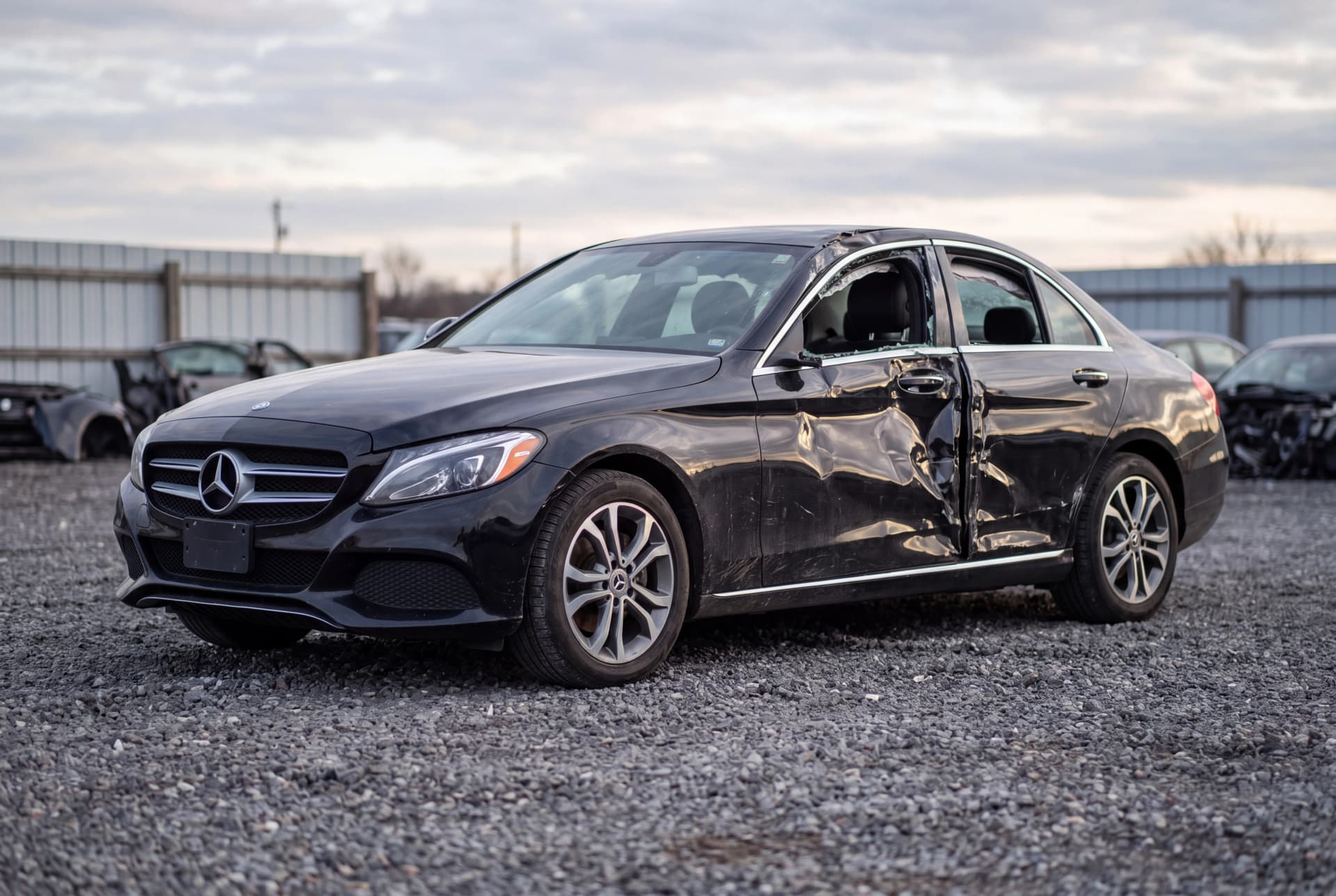 A totaled Black 2016 Mercedes-Benz C-Class C300 after a passenger-side collision